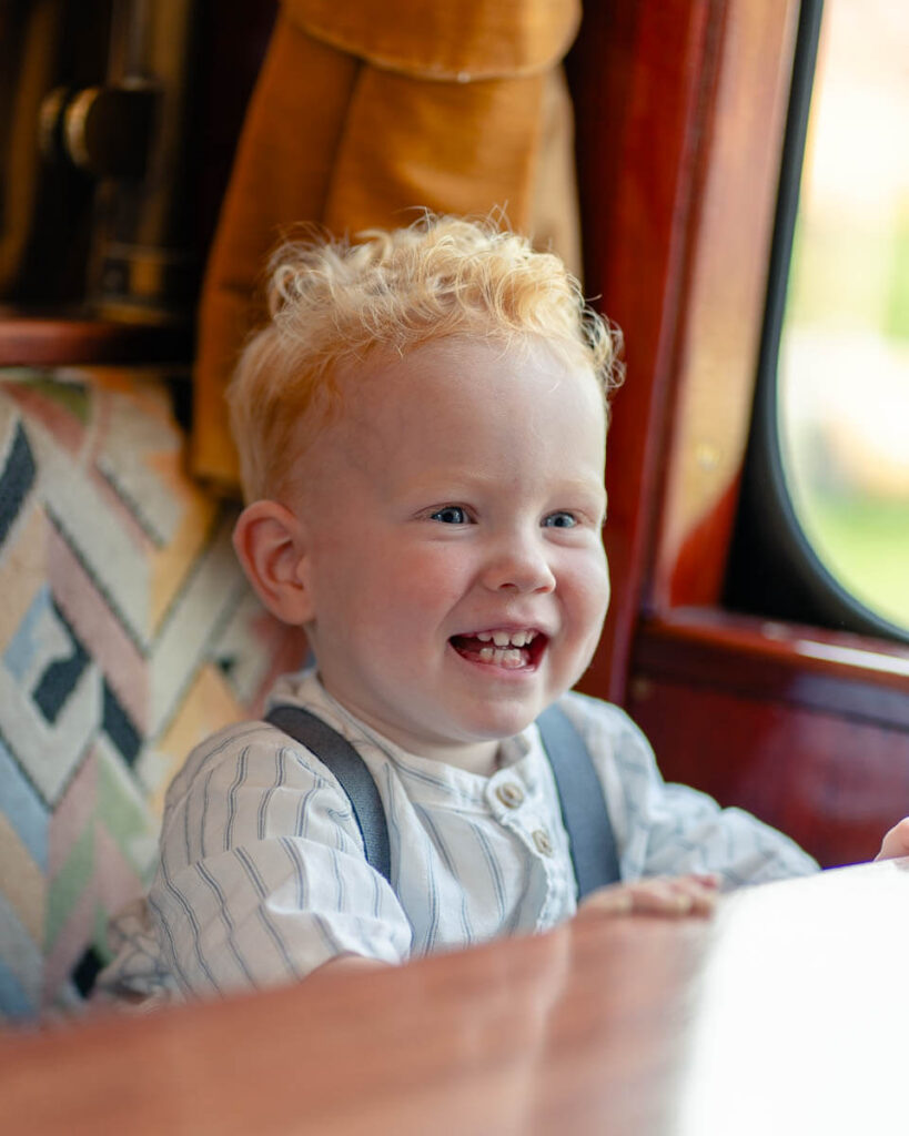Spontane foto van lachend kind in de trein MBS tijdens bruiloft.