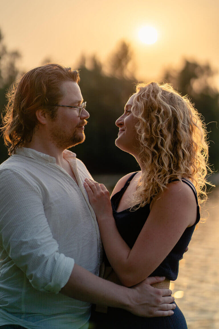 Foto van verliefd koppel gemaakt tijdens een loveshoot. Het gouden uur zorgt voor extra sfeer